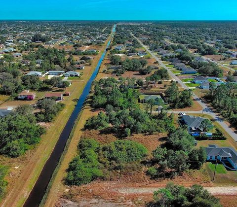 Aerial view of the sold land parcel at 4701 Karen Ave S, Lehigh Acres, FL, beside a canal